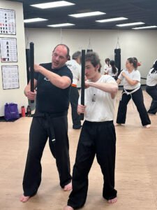 Students practicing martial arts techniques in a training class at KM Martial Arts.
