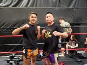 Two Muay Thai fighters posing in the ring at OC Muay Thai gym.