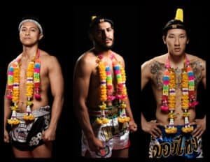 Three Muay Thai fighters in traditional attire with floral garlands and headgear.