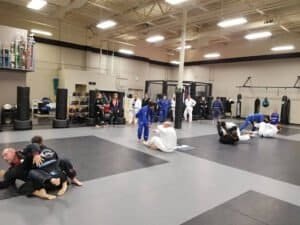 MMA and Jiu Jitsu practitioners training in a spacious gym.