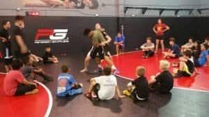 Kids wrestling class at Peterson Grapplers training center in a gym.
