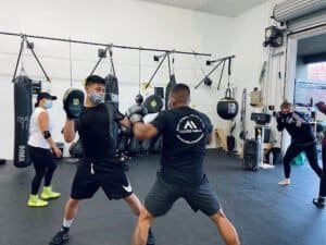 Boxers practicing sparring and training in a modern MMA gym.