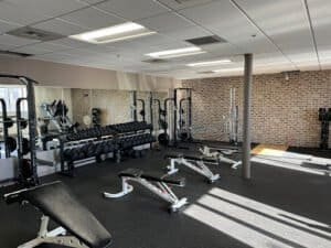 Modern gym with weightlifting and cardio equipment for fitness training.