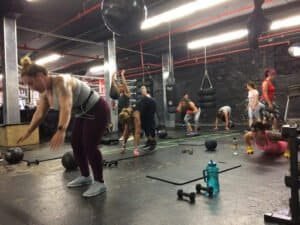 People participating in a fitness class with weights and boxing equipment.