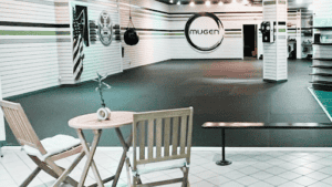 Modern gym interior at Mugen Martial Arts and Fitness with training area and logo.