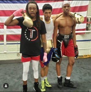 Young boxers training in the gym with boxing gloves and gear.