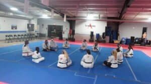 Martial arts students practicing in a spacious training gym.