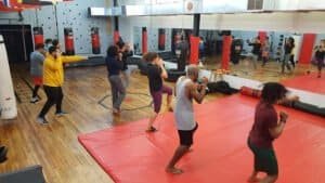 Group of people practicing boxing techniques in a gym.