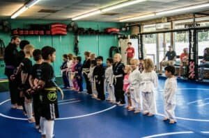 Children in martial arts uniforms lined up in training at Epic Fight & Fitness.