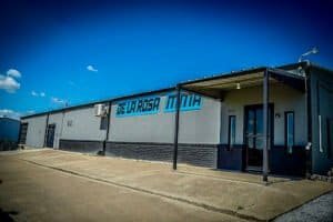 Exterior view of De La Rosa MMA gym with clear blue sky.