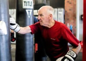 Elderly man practicing boxing at Rock Steady Boxing Knoxville gym.