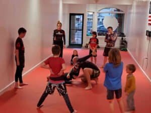 Children practicing martial arts techniques in a training room at The Grindhouse.