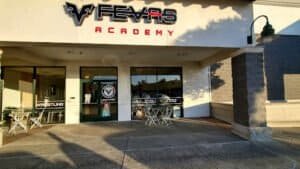 Exterior view of Fevas Academy boxing gym with entrance and outdoor seating.