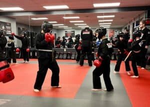 Children practicing boxing in a martial arts class at Cosens Martial Arts Flushing.