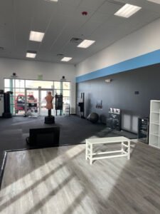 Empty boxing gym with training equipment and mannequin for boxing practice.