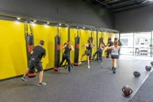People training with punching bags in a boxing fitness class at HIT HARD FITBOXING.