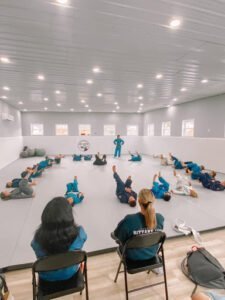 Group of students practicing Jiu-Jitsu on mats in a spacious training room.