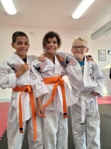 Young martial artists in uniform with orange belts at Twin Falls Martial Arts.