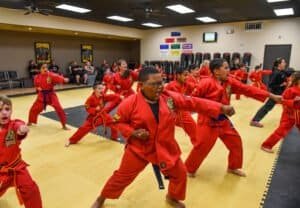 Children practicing martial arts in red uniforms during class at Acadiana Karate.
