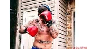 Boxer wearing red gloves and headgear during training session.