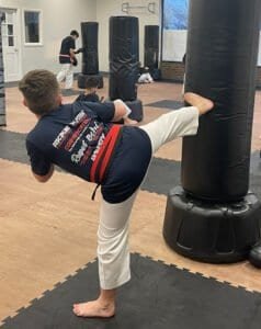 Young martial artist practicing kick at U.S. Elite Martial Arts & Fitness Center.