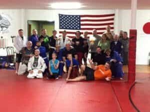 Group photo of students and instructors at Brazilian Jiu-Jitsu class.