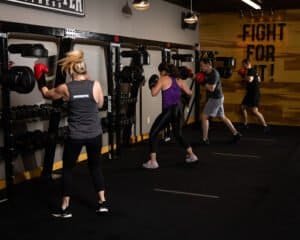 Group of women boxing with gloves in a gym at Focusmaster Fitness.