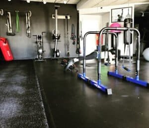 Fitness gym with various workout equipment and weights for strength training.