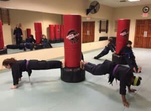 Children practicing martial arts with punching bags at Heijoshin Dojo.