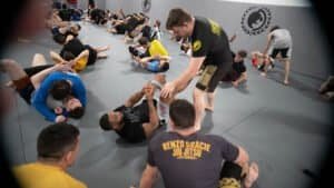 Students practicing Brazilian Jiu-Jitsu techniques in a training session.
