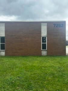 Brick building with the number 7252 on the wall under cloudy sky.