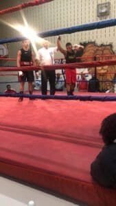 Boxers and referee in the boxing ring during a match at DNA LEVEL C Boxing Club.