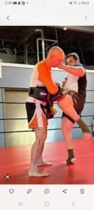 Two fighters practicing Muay Thai in a gym with focus on technique.