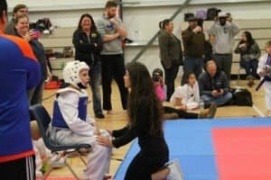 Young taekwondo athlete receiving coaching during competition.