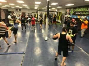 Group of people practicing kickboxing at Absolute Boxing gym.