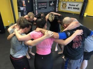 MMA fighters in a huddle during training at BFC Extreme gym.