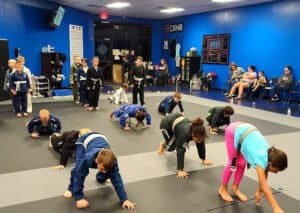 Children practicing Jiu-Jitsu techniques in a martial arts class at Gracie Fernandina.