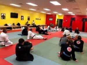 Students practicing Brazilian Jiu-Jitsu techniques in a training session.