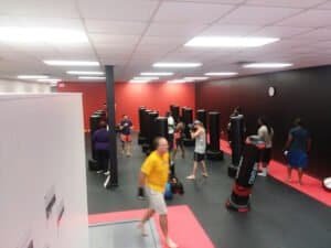 People practicing Krav Maga techniques in a martial arts gym.